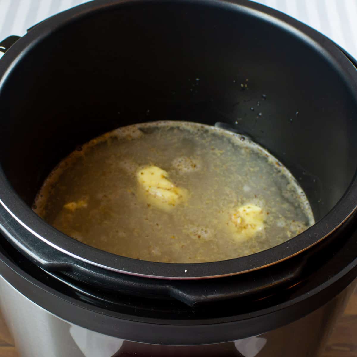 A pot half filled with water and butter.