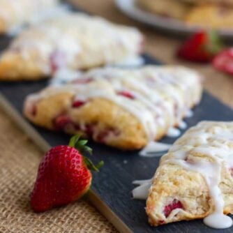 Baked scones with icing drizzled on them.