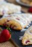 Baked scones with icing drizzled on them.