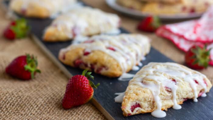 Baked scones with icing drizzled on them.