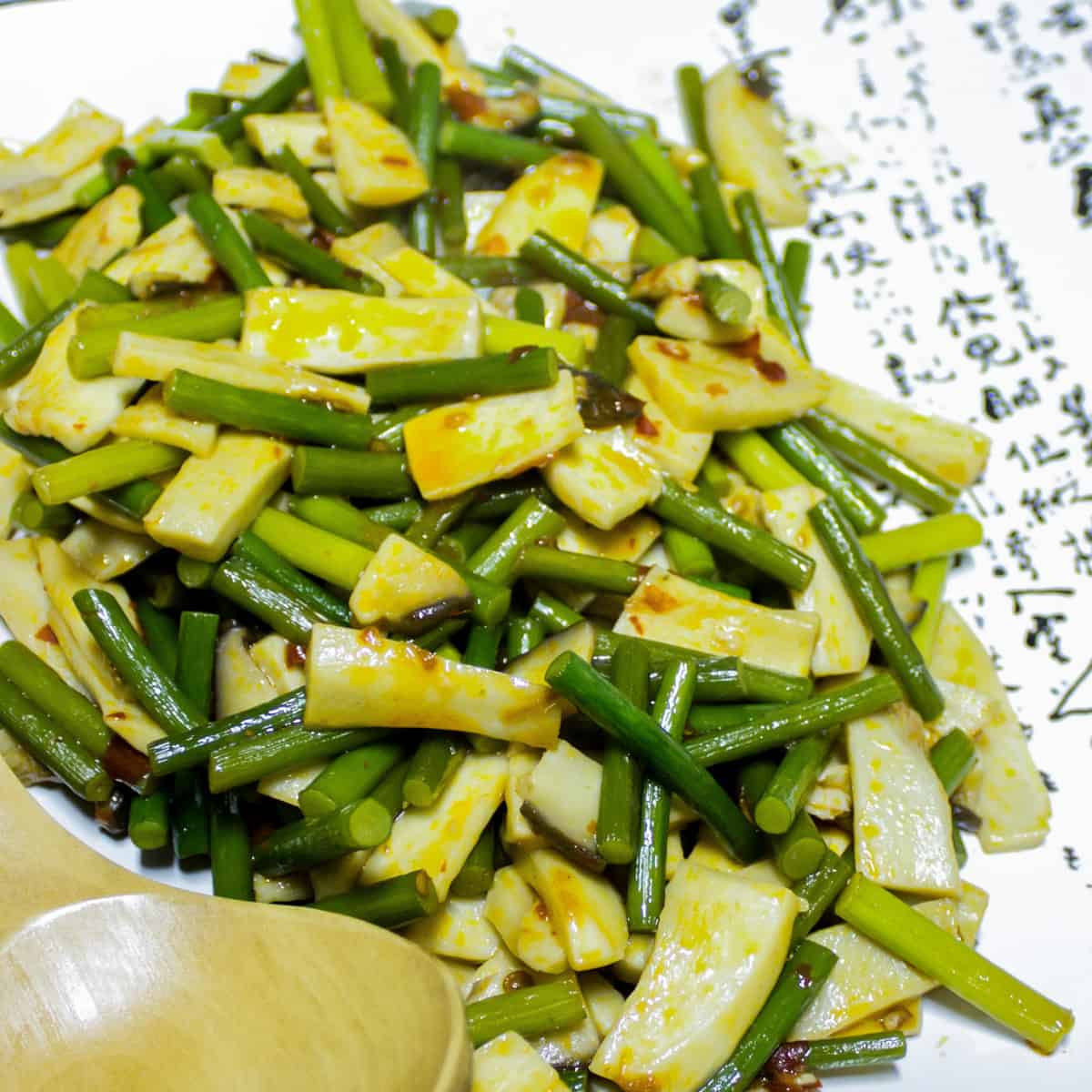 Stir fry on a plate with a large wooden spoon.