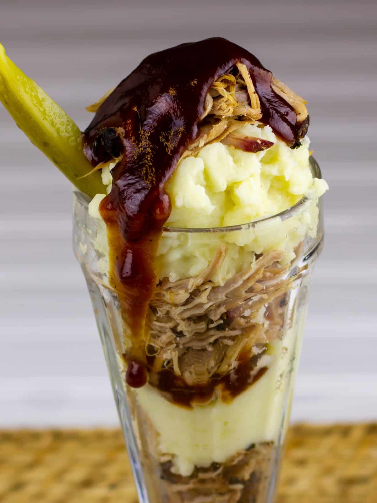 Close up picture of a savoury sundae made with pork and potatoes.