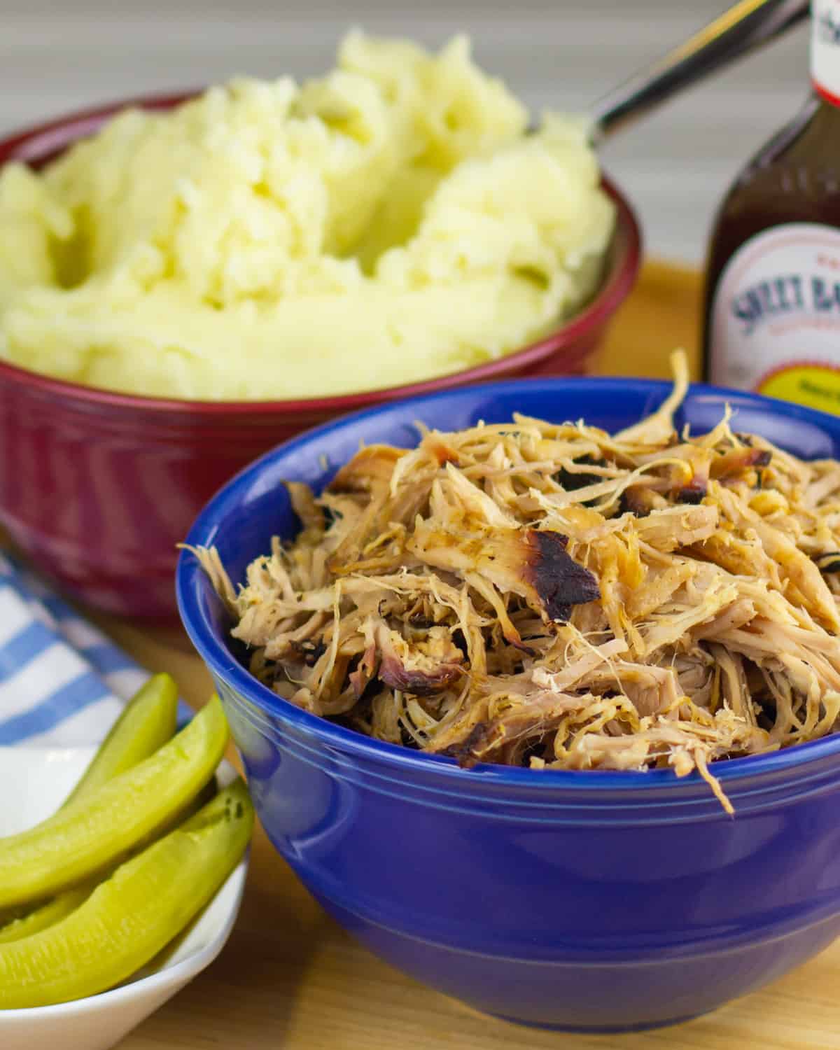 Two bowls with mashed potatoes and shredded pork.