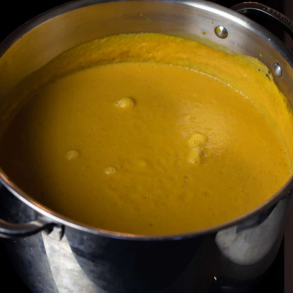 Creamy soup in a pot simmering.
