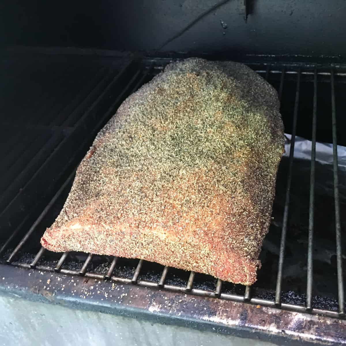 A whole brisket in a smoker.