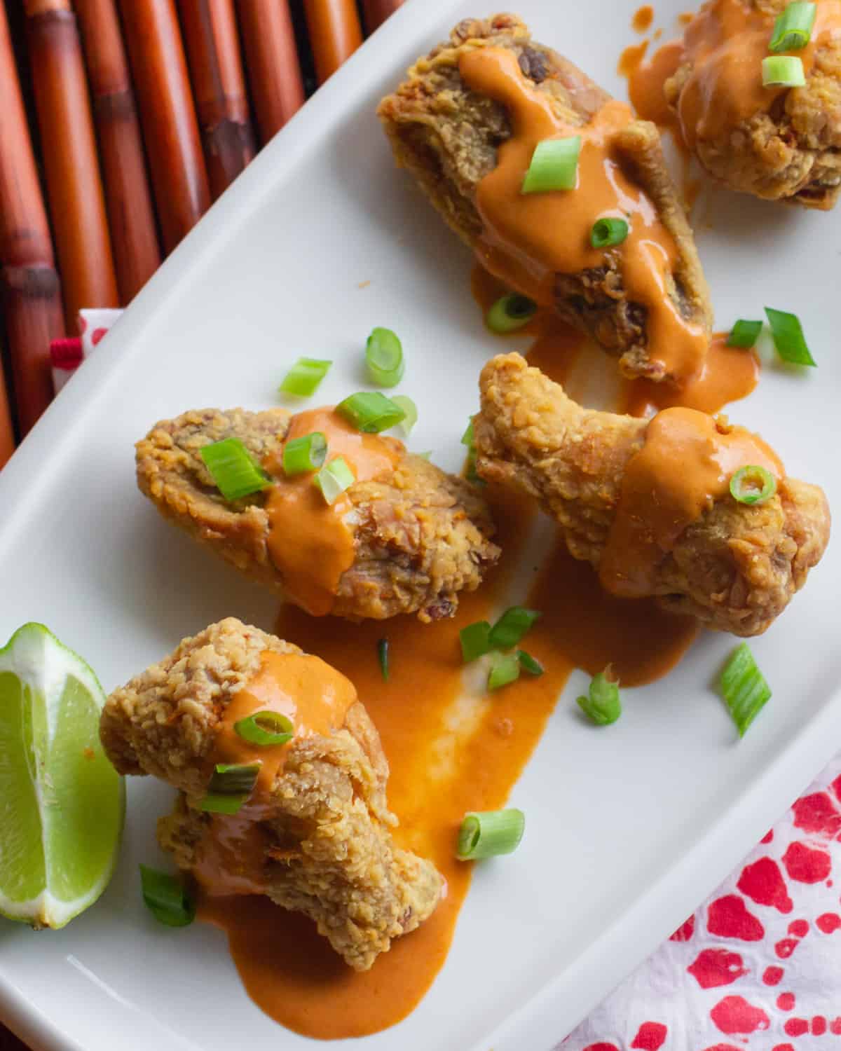 Deep fried wings spread out on a plate.