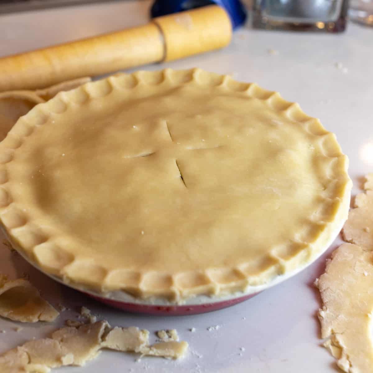 Pie pastry place on top of a dish and pinched to close.