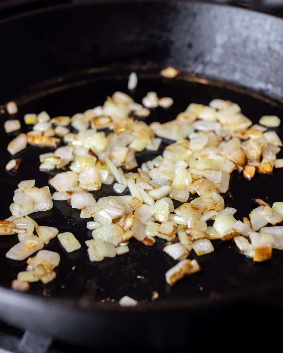 Sautéed diced onions in a cast iron skillet.