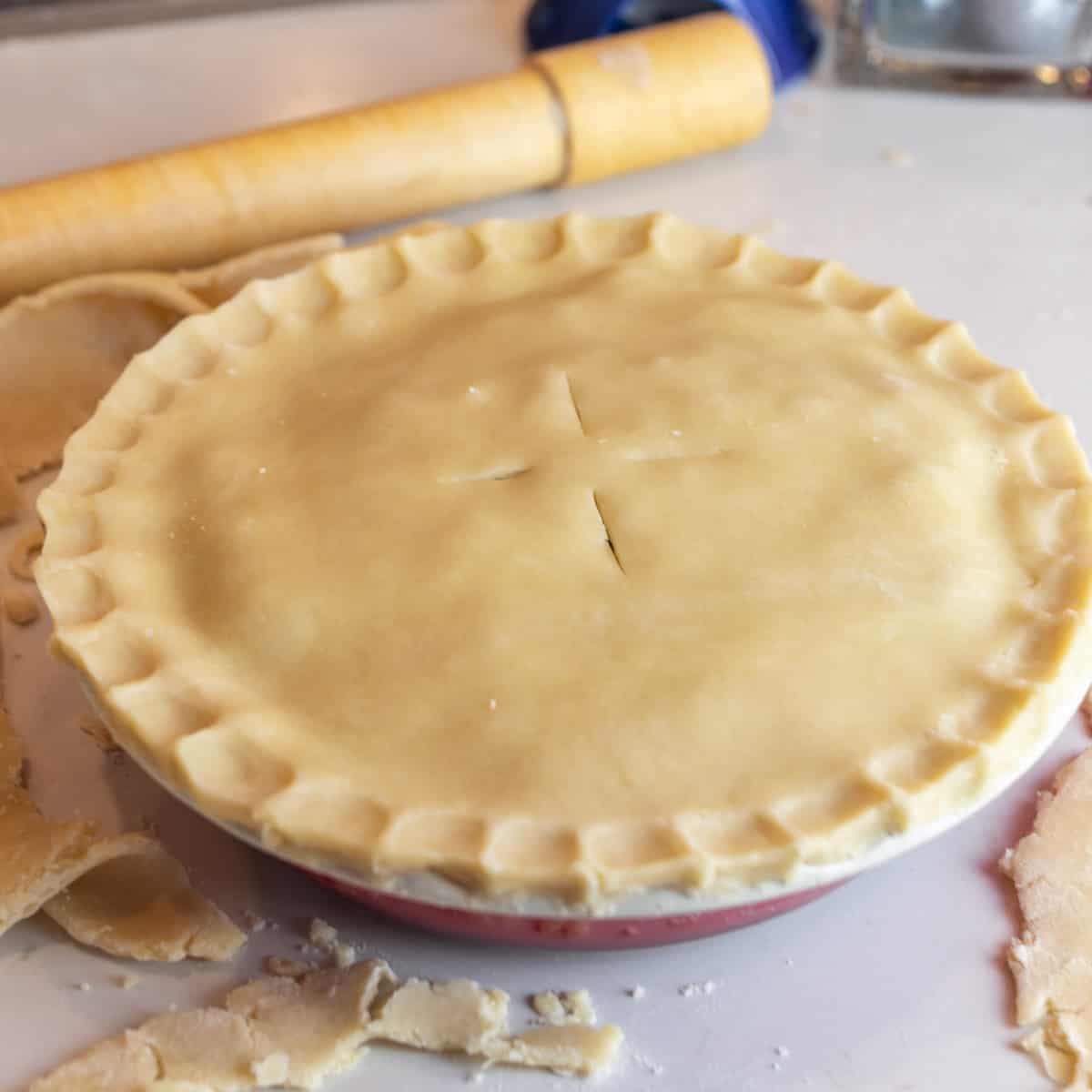 Unbaked pie with a rolling pin behind.