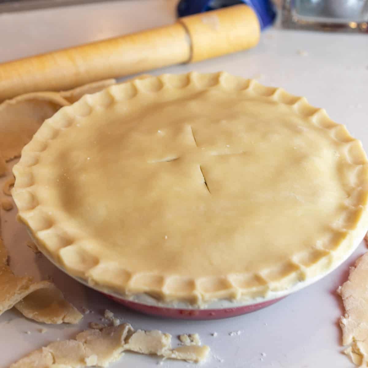 Unbaked pie with a rolling pin behind.