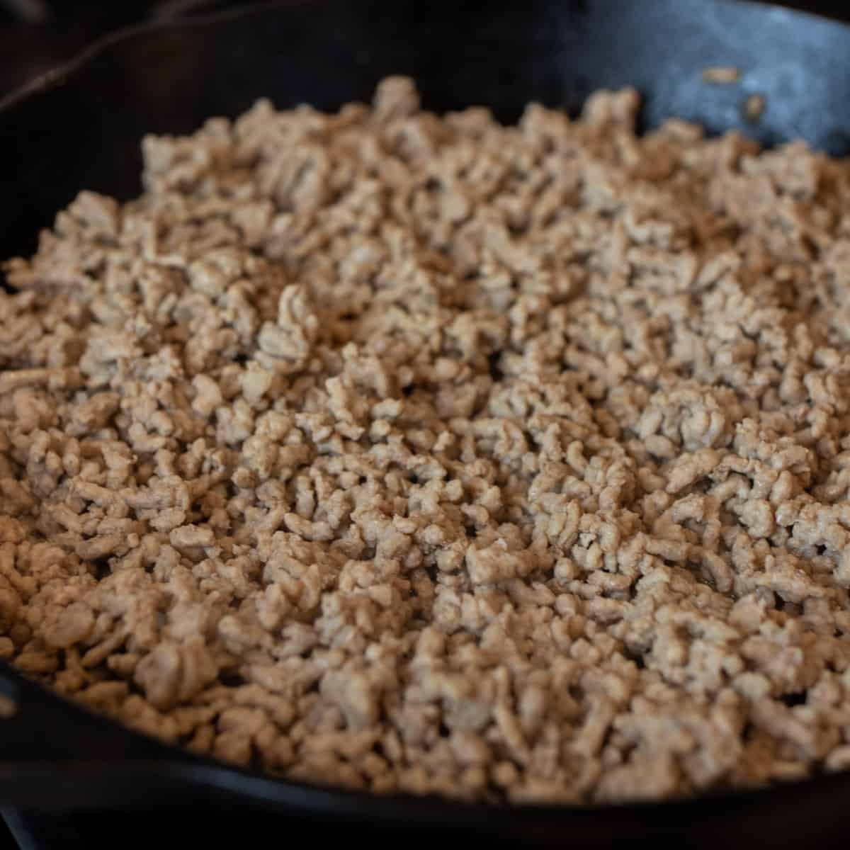 Browned ground pork in a skillet.