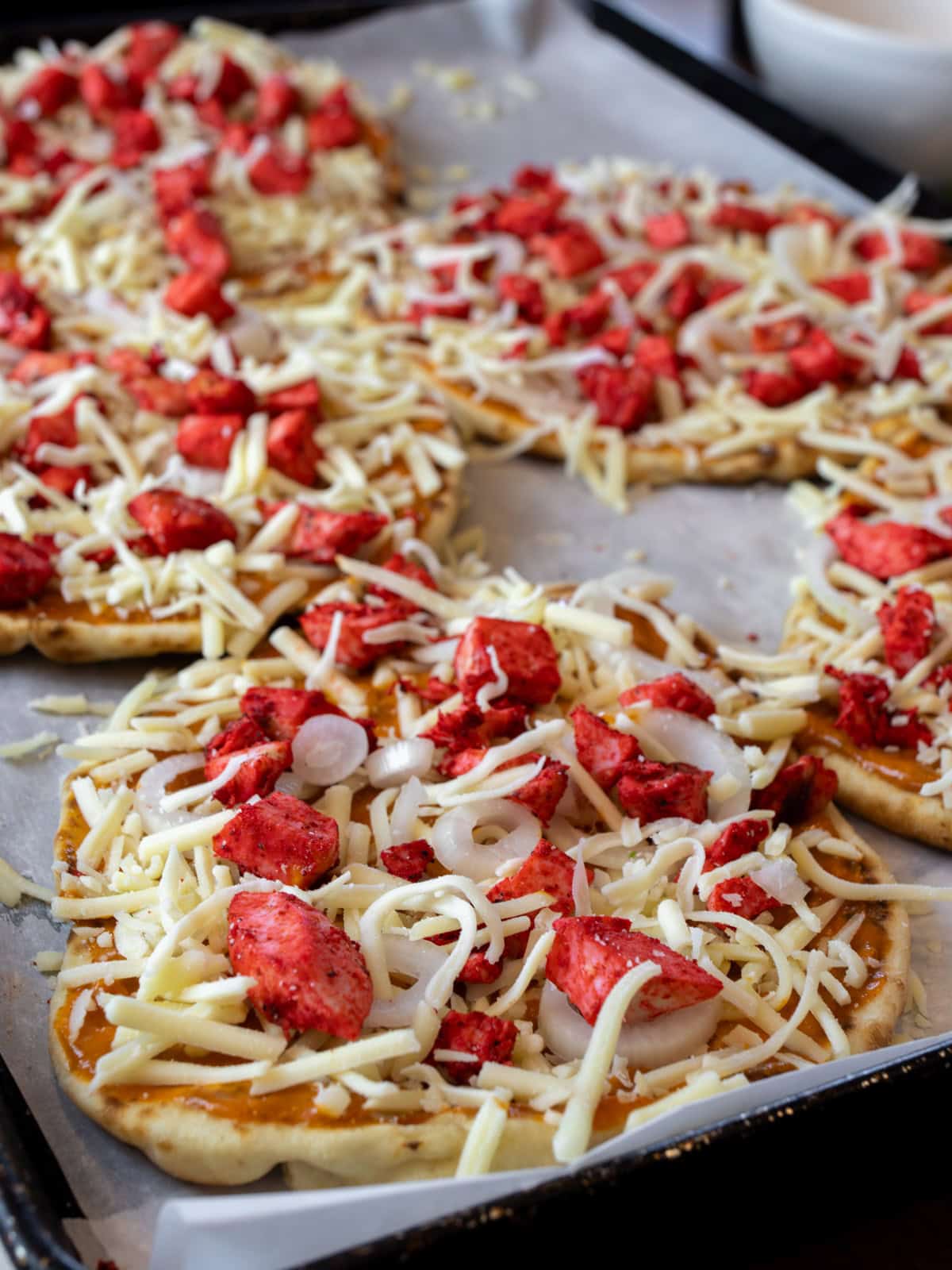 Small pizzas ready to go in the oven.
