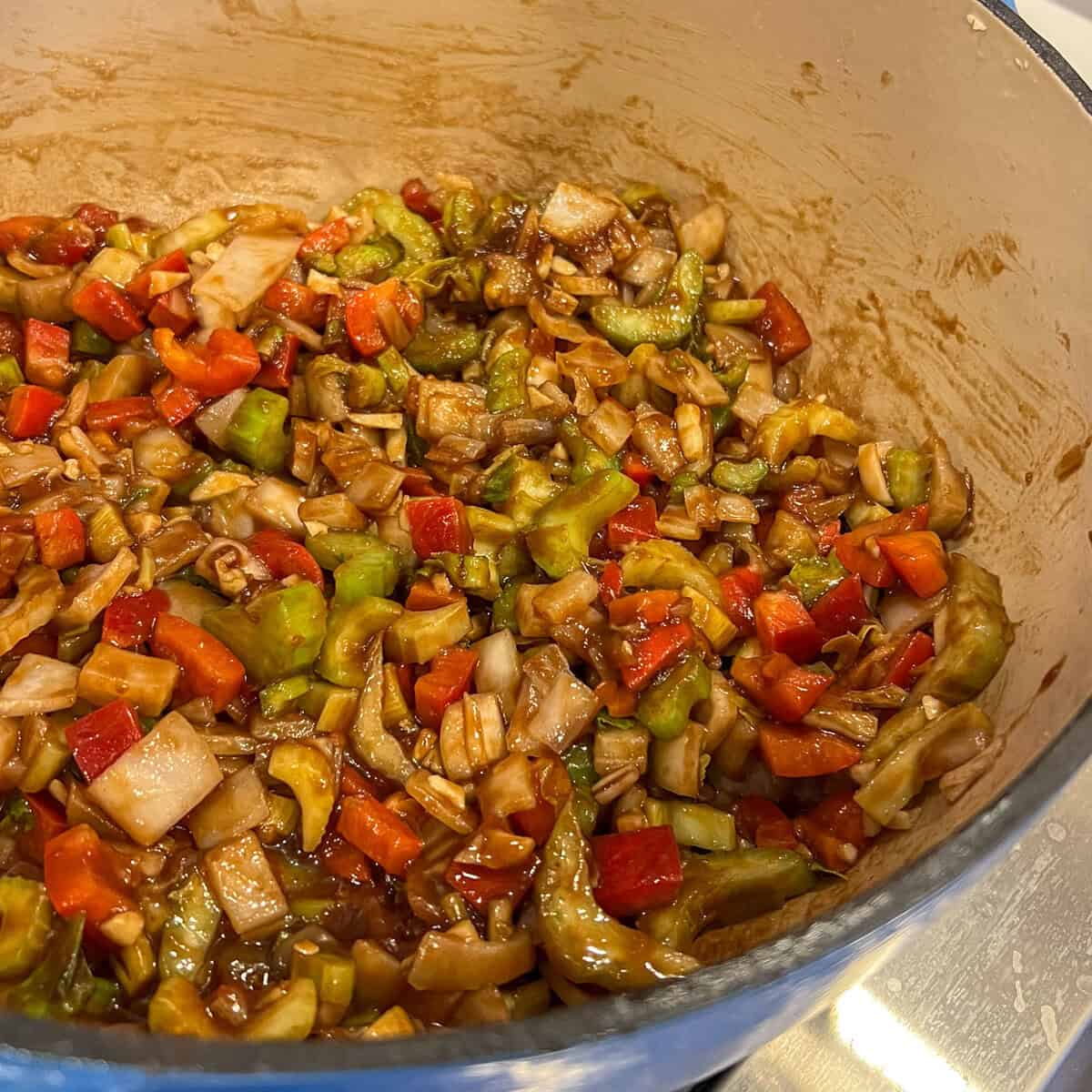 Onions, celery and peppers in a pot sautéing.