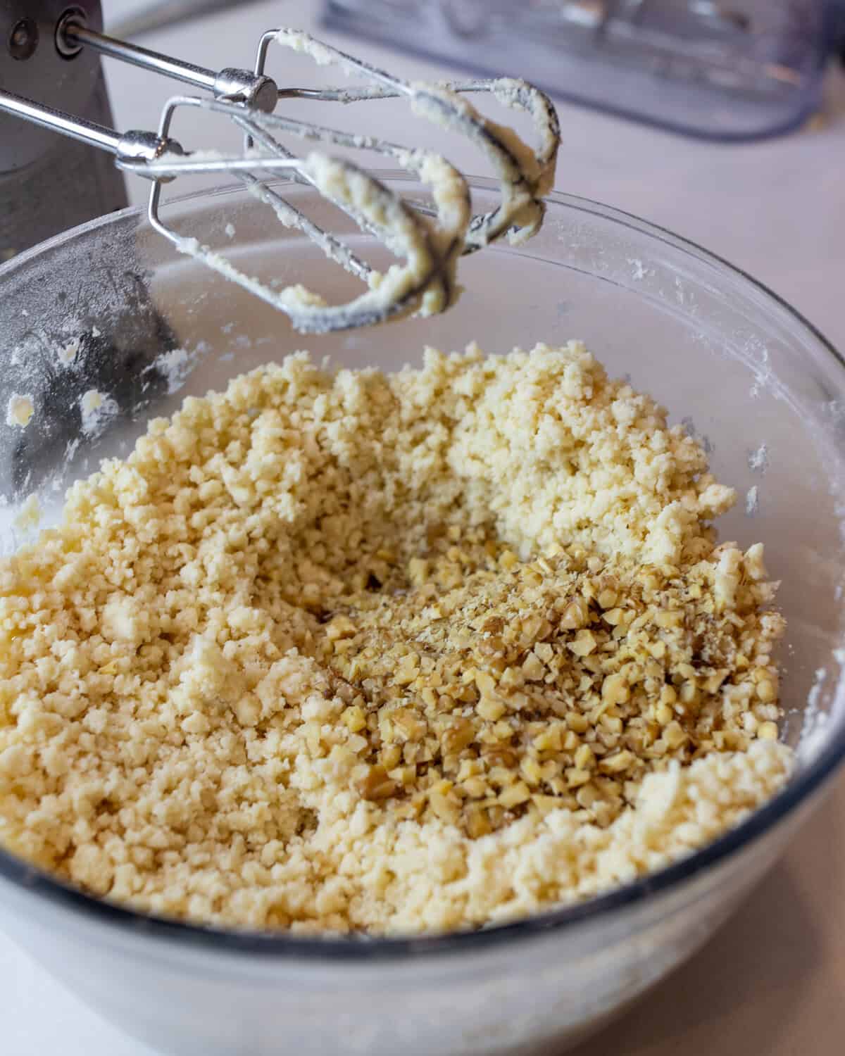 Walnuts in the glass bowl with the cookie dough mixture.