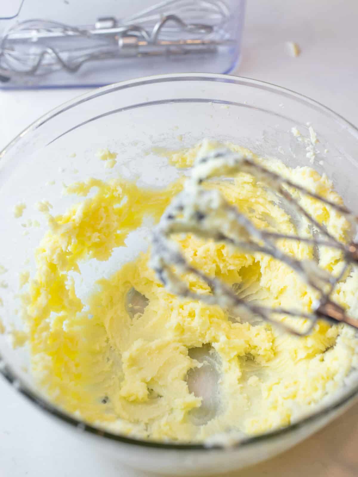 Butter and sugar mixed in a glass bowl.