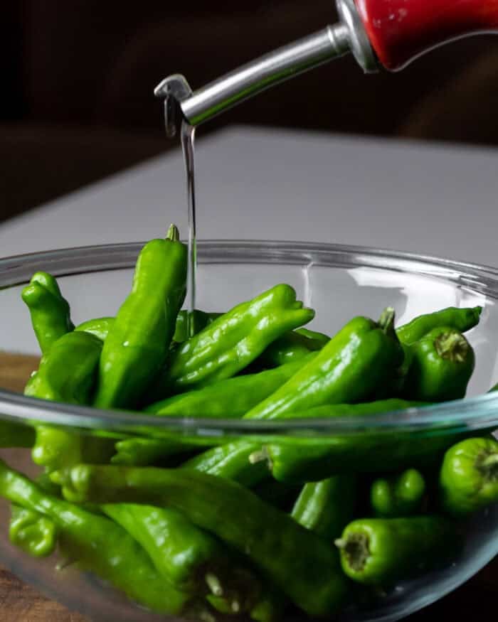 shishito peppers in a bowl with oil